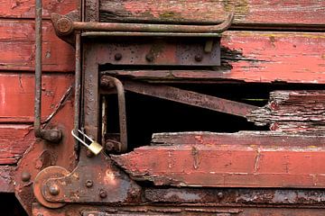 closeup van een trein wagon met een slot en een verrot hout