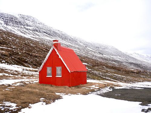 Chalet rouge dans un paysage de neige islandais