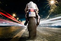 Man on motorcycle at night at high speed