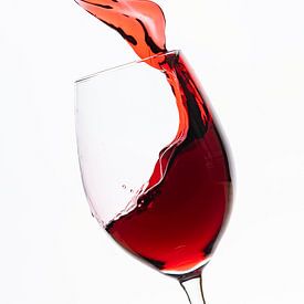 Red wine flows into the wine glass by Roland Brack