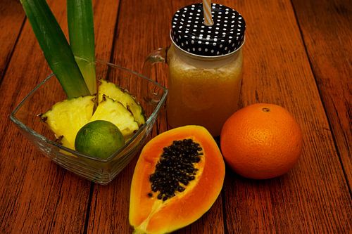 Tropische limonade met ananas, limoen, papaya en sinaasappel