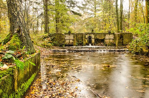 Watercourse with old lock in an autumn forest