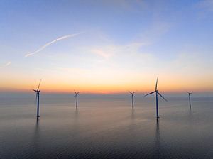 Windturbinen in einem Offshore-Windpark bei Sonnenuntergang