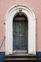 Die Tür mit abblätternder Farbe des rosa Hauses Nr. 14