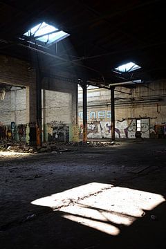 Daglicht dat binnenvalt door een dakraam in een fabrieksgebouw van Heiko Kueverling
