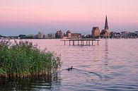 Uitzicht over de Warnow naar de Hanzestad Rostock in de avond van Rico Ködder thumbnail