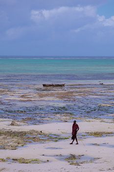 Ein Maasai-Mann posiert bei Ebbe am Strand