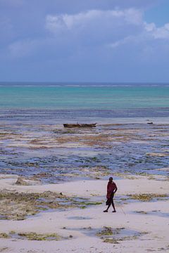 Een maasai man poseert op het strand bij eb van Lisette van Leeuwen
