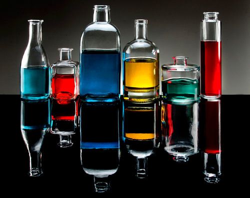 zes flessen met gekleurde vloeistoffen