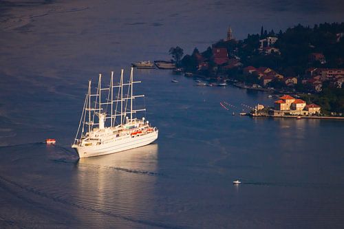 Beautiful cruise ships (one sailing) are far below among the dark blue near the town with red roofs,