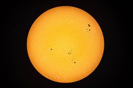A view of our sun with sunspots through a telescope. by Andreas Völkel