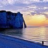 Silhouette on beach in evening sun near rock arch by Christa Krus