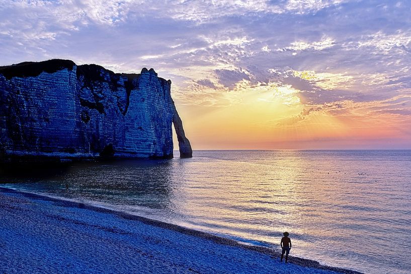 Silhouette on beach in evening sun near rock arch by Christa Krus