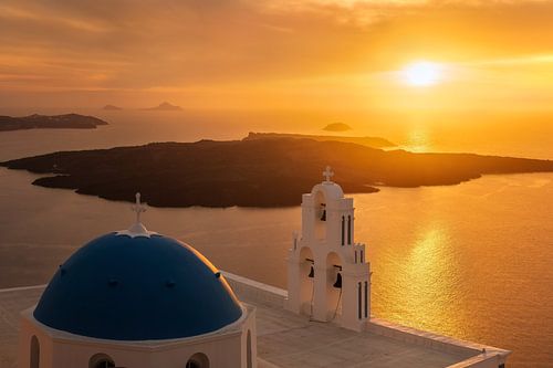 Kerk met blauwe koepel bij zonsondergang op het eiland Santorini in Griekenland
