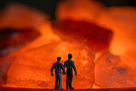 Männer zusammen Hand in Hand mit Blick auf die orange Feuer in Steinen von Jolanda de Jong-Jansen Miniaturansicht