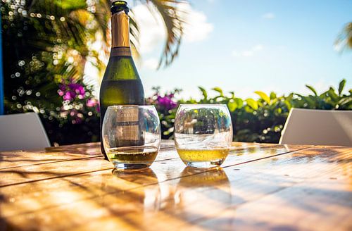 champagne fles en glazen op tropisch eiland