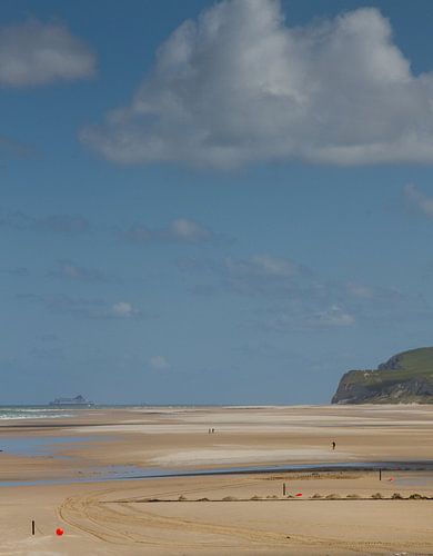 Strand met kleine kleurige details en blauwe wolkenlucht
