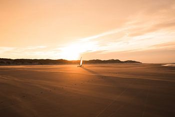 Leerer Strand, goldene Sonne, im Wind tanzende Segel.