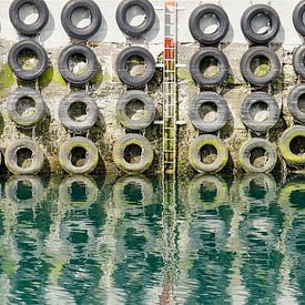 Car tires on the quay wall by Frans Blok