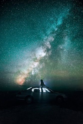 Silhouet van een auto tegen de nachtelijke Melkweg