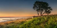 Baltic Sea near Ahrenshoop with beach and thatched house at sunset