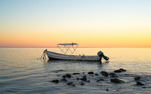 Motorboot bij zonsondergang in een tropische Caribische zee