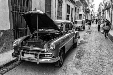 Vintage car with open hood in old town of Havana Cuba in black and white