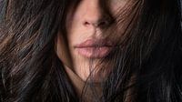 Foto von schönen weiblichen Gesicht mit langen dunklen Haaren Schönheit Zweig