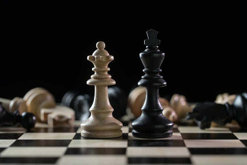 Chess pieces queen and king in front of a of fallen chessmen after a battlefield on a chessboard aga by Maren Winter
