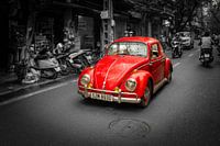 Volkswagen Beetle driving down the street.