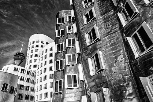 Gehry-gebouwen in de mediahaven in Düsseldorf met de Rijntoren in zwart-wit