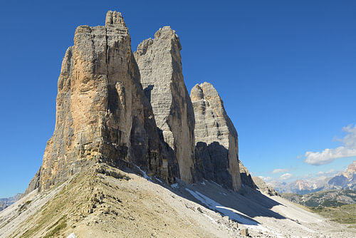 Die Gipfel der Drei Zinnen ragen vor blauen Himmel empor