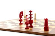 Rode en witte ivoren schaakstukken op een houten bord par Wim Stolwerk Aperçu