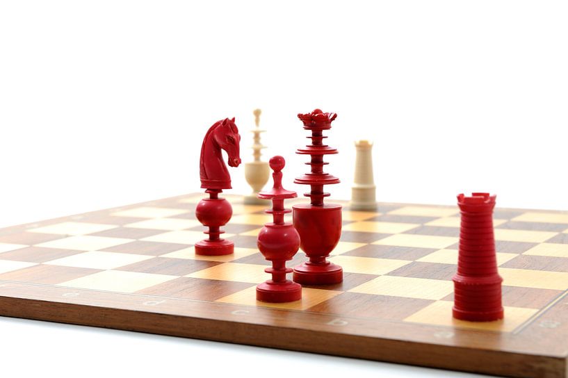 Rode en witte ivoren schaakstukken op een houten bord par Wim Stolwerk