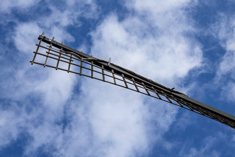 Le moulin navigue dans un ciel bleu avec des nuages blancs. sur Margreet van Tricht