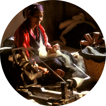 Tibetaanse vrouw aan een spinnewiel