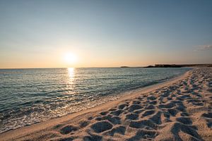 Risotto Reis Strand Is Arutas auf Sardinien zum Sonnenuntergang mit glitzerndem Meer und Steinen
