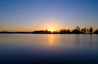 Untergehende Sonne an einem See, Blick auf Boote und Hütten. von Lidewij Olive Miniaturansicht