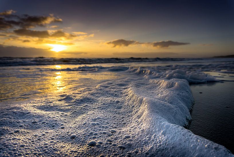 Foam on the beach during sunset by Peter van der Waard