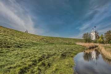 The historic white lighthouse of Workum on the dike mirrored in the ditch by Harrie Muis