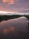 Reflectie van de zonsondergang en wandelaars van Max van Gils thumbnail