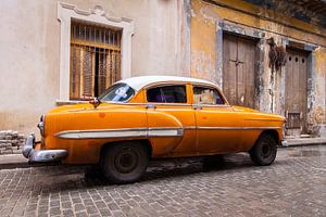 Oranje oldtimer in Cuba van Eveline Dekkers