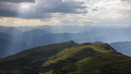 Zonnestralen boven de Pizol - lichtspel op een groene heuvel