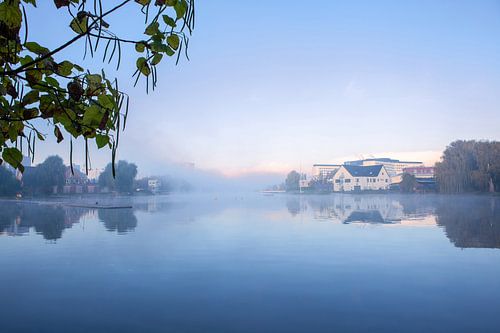 Watersportbaan met opkomende mistbanken over het water