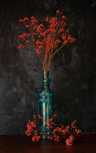 Orange gypsophila in blue bottle.