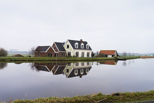 Boerderij aan de rand van water met reflectie in de buurt van Amsterdam, Nederland