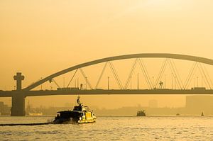 Van Brienenoordbrug bij zonsopkomst met de Waterbus van Wijnand Loven