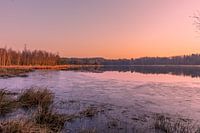 Zonsopkomst aan het water met een laagje ijs.