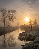 Kalter Wintersonnenaufgang mit Sonne und Nebel in der Nähe eines Grabens in Leusden
