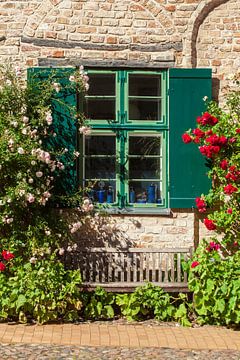 Ancienne fenêtre avec des fleurs d'été sur la façade d'une maison historique près de l'église Nikola